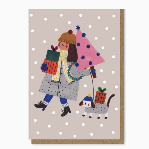 Julekort i formatet A6 med dame og hund som bærer julegaver og juletre illustrert av Daria Solak Illustrations