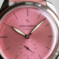 Runde Pale Pink klokke fra Von Doren med rosa sunburst-skive og matchende skinnreim