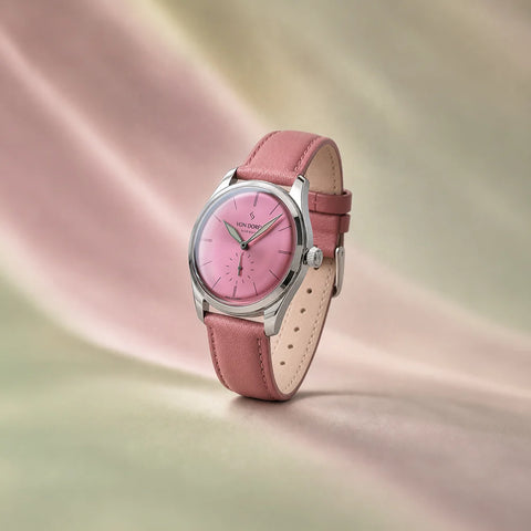 Runde Pale Pink klokke fra Von Doren med rosa sunburst-skive og matchende skinnreim