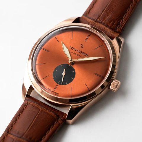 Runde Vintage klokke fra Von Doren med kobber- og laksefarget urskive og sort subdial